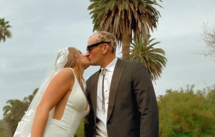 Couple kissing under palm trees in Santa Barbara